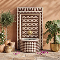 a decorative fountain with a tiled design, surrounded by potted plants and flowers, creating a serene and inviting atmosphere.