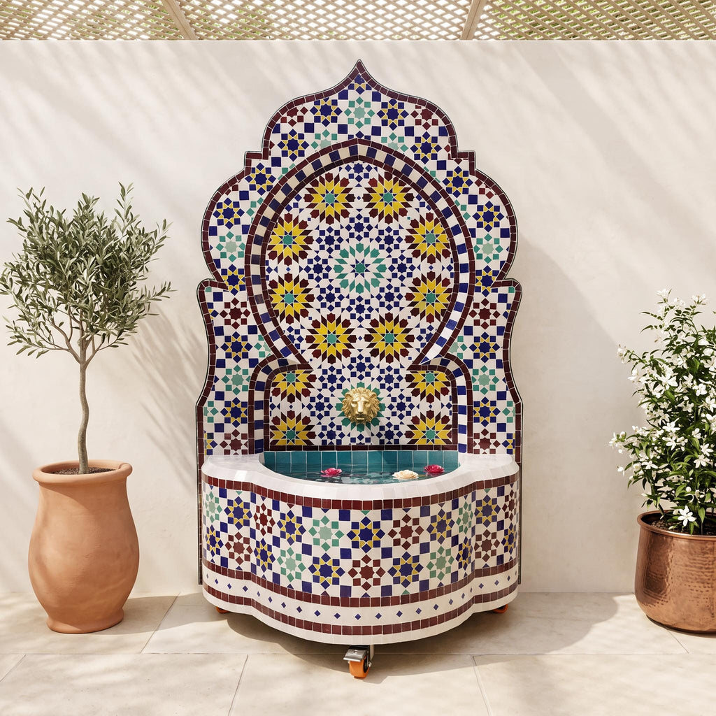 a decorative fountain with a mosaic design, surrounded by potted plants and a terracotta pot.