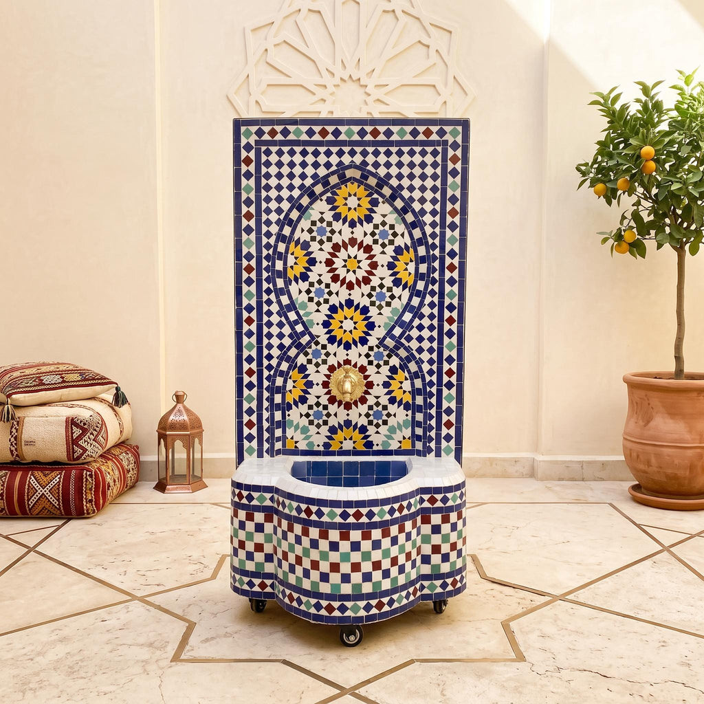 a decorative tile fountain with a blue and white mosaic design, situated in a room with a tiled floor and a potted plant.