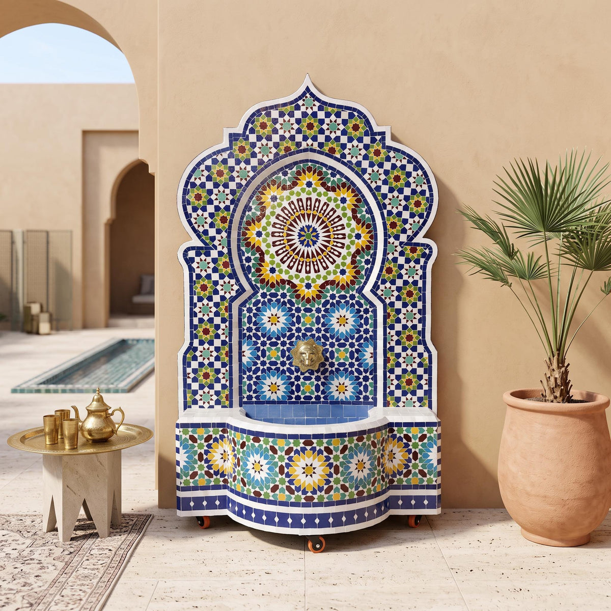 a decorative fountain with a mosaic design, situated in an outdoor setting with a table and potted plant nearby.