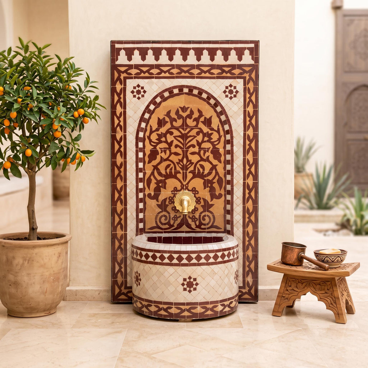 a decorative fountain with a tree-like design, surrounded by potted plants and a wooden stool.