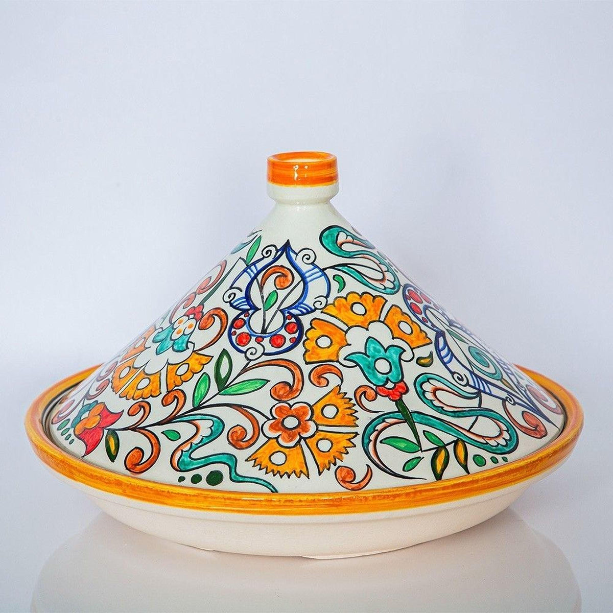 A colorful ceramic pot with a floral pattern and an orange lid, placed on a white surface.