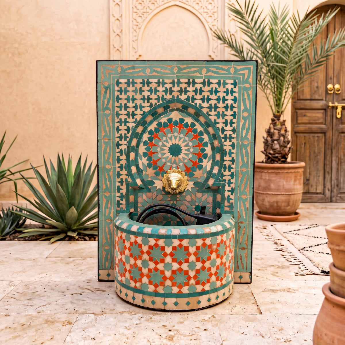 a decorative fountain with a mosaic design, surrounded by potted plants and a wooden door.