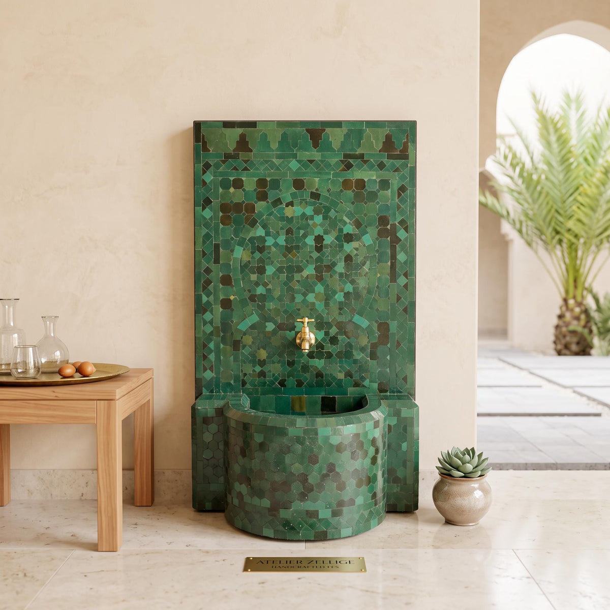 a modern bathroom with a green mosaic tile wall, a round green sink, and a wooden table with a tray and a potted plant.