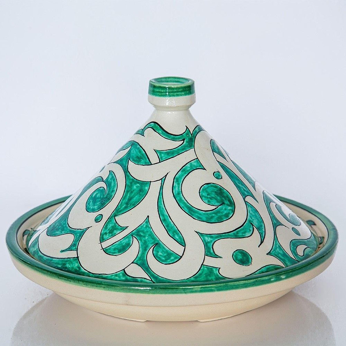 A decorative ceramic dish with a green and white pattern, featuring a pointed lid and a flared rim.