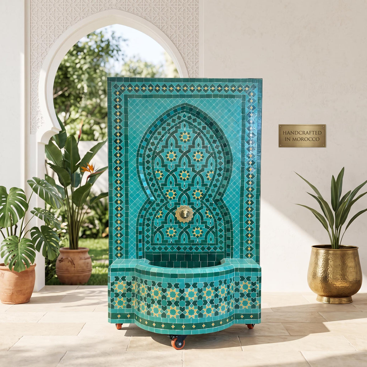 a large, ornate fountain with a blue and green tile design, situated in an outdoor setting with potted plants and a white wall.