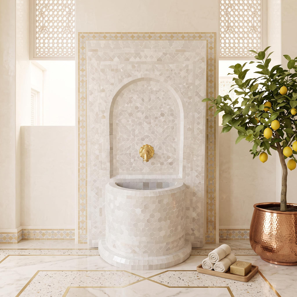 a luxurious bathroom with a white marble sink, a potted lemon tree, and a decorative tile archway.