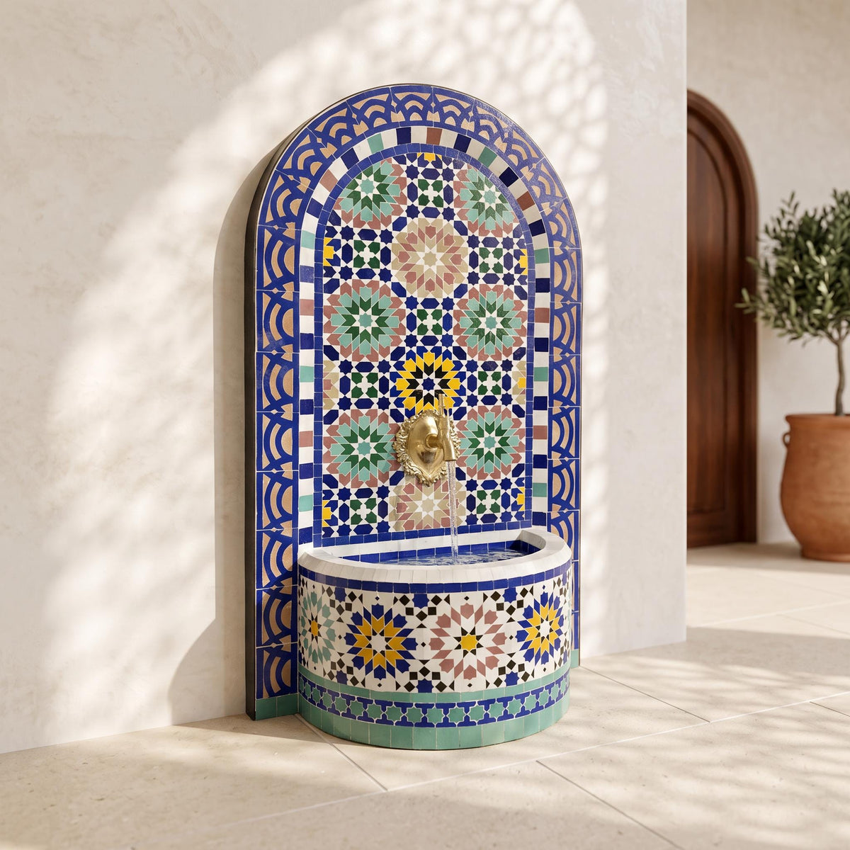 a decorative fountain with a mosaic design, situated in a room with a wooden door and a potted plant in the background.