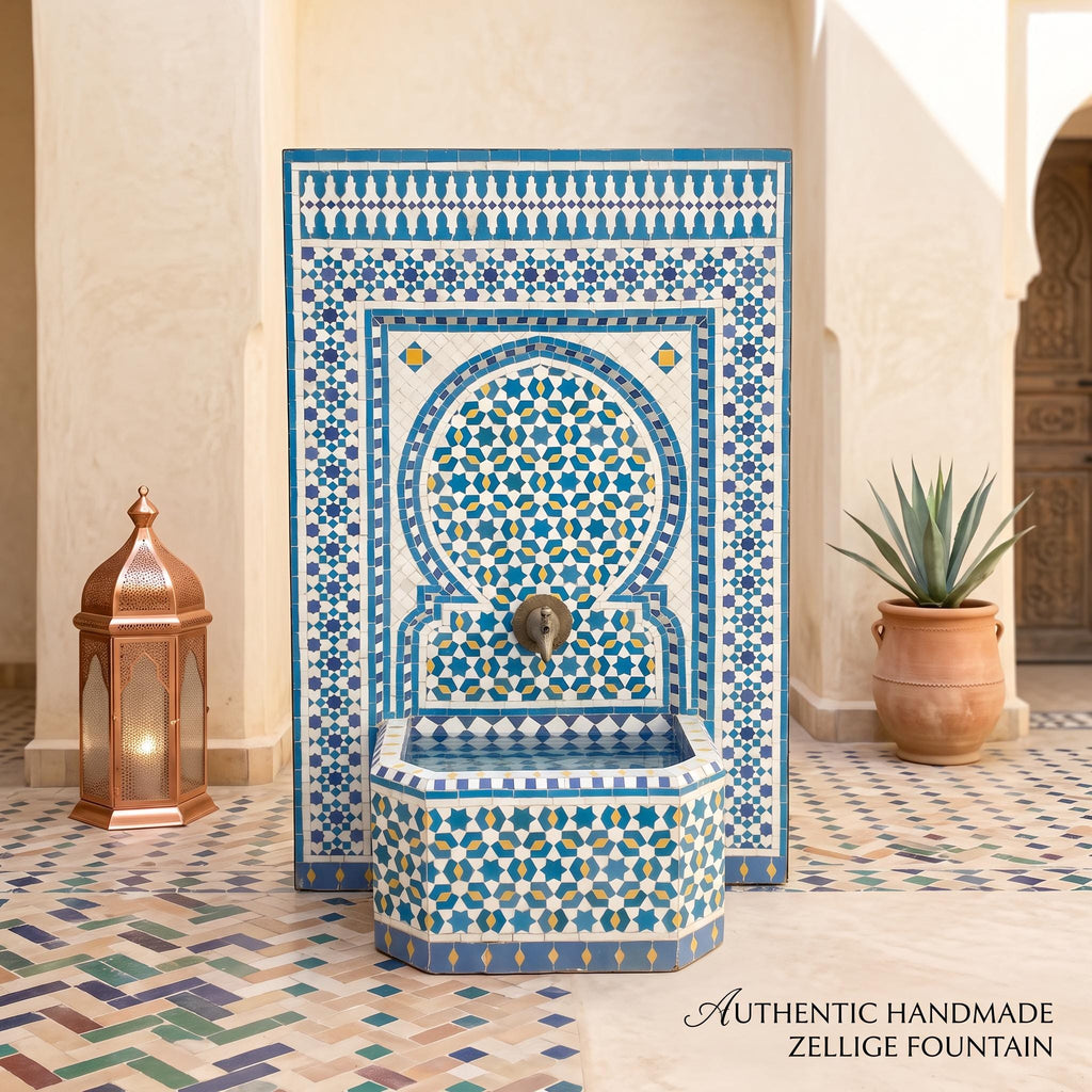 a beautifully crafted, authentic handmade Zellice fountain, with a blue and white tile pattern and a copper lantern on the left side. The fountain is situated in a courtyard with a tiled floor and a potted plant nearby.
