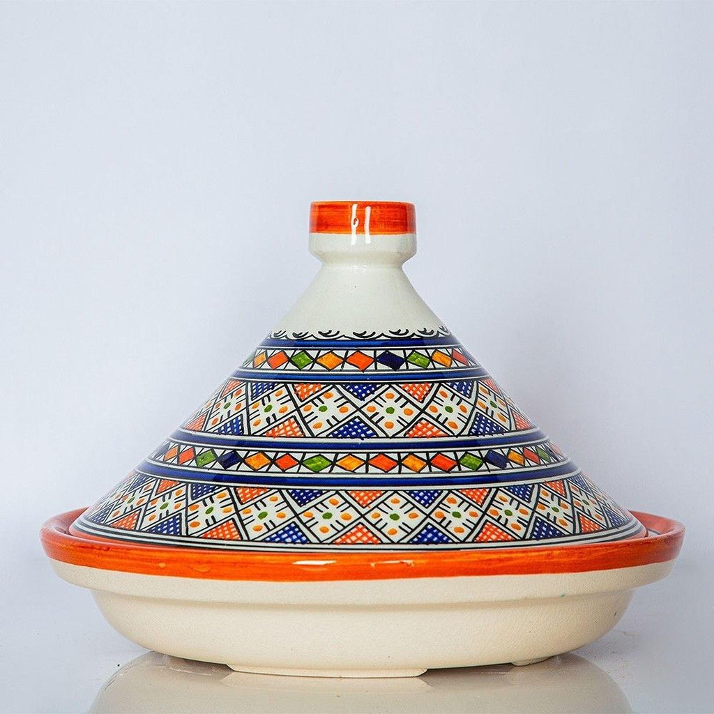 A ceramic cooking pot with a colorful, geometric pattern on its lid and a red rim.
